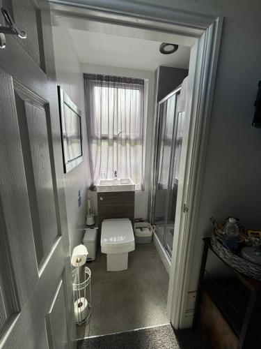 a small bathroom with a toilet and a window at The Queens Hotel Harlech in Harlech