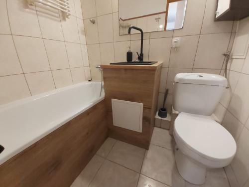 La salle de bains est pourvue de toilettes, d'une baignoire et d'un lavabo. dans l'établissement 2050 Zwycięstwa 23 - Tanie Pokoje - samodzielne zameldowanie - self check in, à Poznań