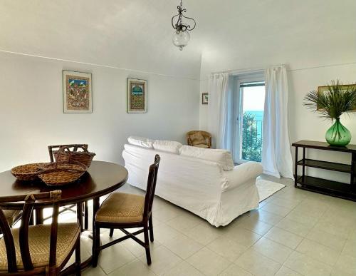 een woonkamer met een wit bed en een tafel bij LA CASA SUL MARE in San Vito Chietino