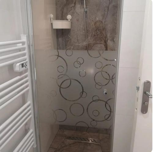 une douche avec une porte vitrée dans une salle de bain dans l'établissement Maison papa, à Nice