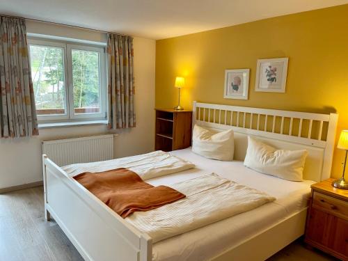 ein Schlafzimmer mit einem großen weißen Bett und einem Fenster in der Unterkunft Haus Am Mühlbach - SommerBergBahn unlimited kostenlos in Oberstdorf