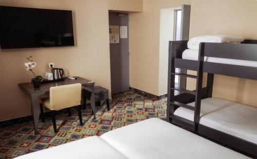 a room with a desk and a bed and a bunk bed at The Originals Boutique, Hôtel Danieli, Avignon in Avignon