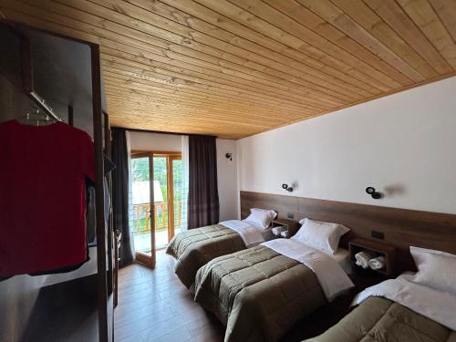 a room with three beds and a flat screen tv at Bujtina Terthorja in Theth