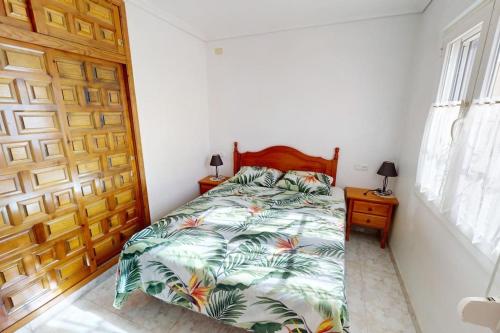 a bedroom with a bed and a wooden door at Casa 1227 in Los Alcázares