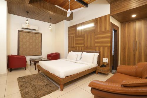 a bedroom with a bed and a chair and a couch at Hotel Razia inn " A Unit of Sihag Construction & Real Estate Pvt Limited " in Hisār