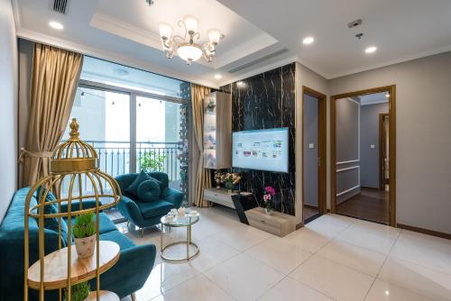 VINHOMES LANDMARK CONDOTEL SUITE في مدينة هوشي منه: غرفة معيشة مع أريكة وتلفزيون