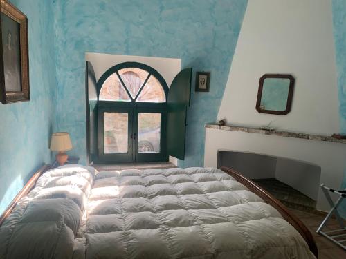un grande letto in una stanza con finestra di Casale San Francesco Casa Pernicoló a Cirò
