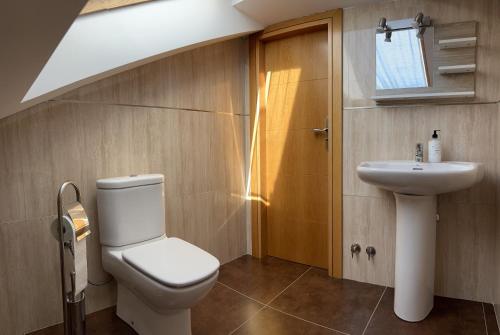 a bathroom with a toilet and a sink at La Libélula in El Espinar