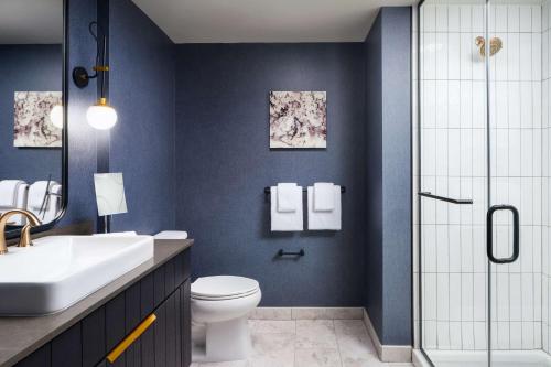 a bathroom with a toilet and a sink and a shower at The Hoffmann Hotel Basalt Aspen Tapestry Collection Hilton in Basalt