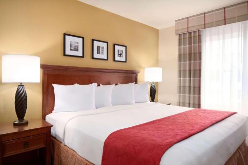 uma cama num quarto de hotel com duas lâmpadas em Country Inn & Suites by Radisson, Champaign North, IL em Champaign