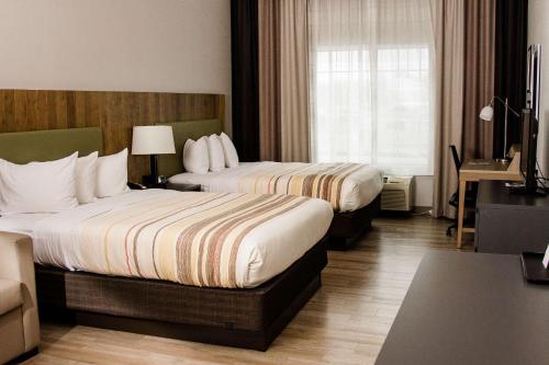 Habitación de hotel con 2 camas y ventana en Country Inn & Suites by Radisson, Winchester, VA, en Winchester