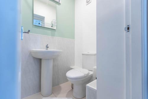 a bathroom with a white toilet and a sink at Windermere Studio Rooms in Windermere