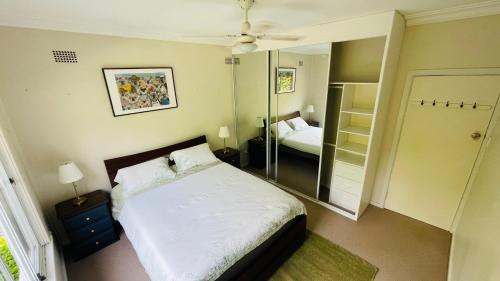 a small bedroom with a bed and a mirror at COMFORT QUEEN GARDEN VIEW ROOM MACQUARIE PARK RYDE in Sydney