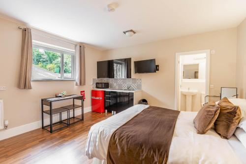 a bedroom with a large bed and a kitchen at Windermere Studio Rooms - with Free Car Parking Onsite in Windermere