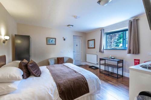 a bedroom with a large bed and a sink at Windermere Studio Rooms in Windermere