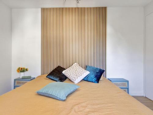 un lit avec quatre oreillers dessus dans l'établissement Appartement en plein cœur de Vannes, à Vannes