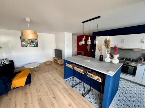 - une cuisine avec un îlot bleu dans l'établissement L'appartement Eclat contemporain -310, à Rouen
