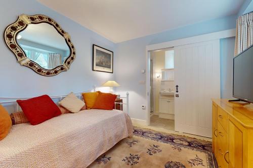a bedroom with a bed with a mirror on the wall at The Wool Barn Simonsbath in Exford