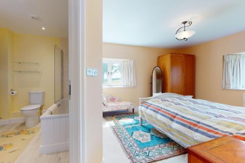 a bedroom with a bed and a bathroom at The Wool Barn Simonsbath in Exford