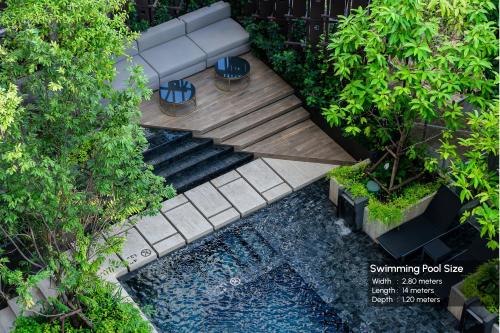 an overhead view of a garden with a bench and water at Gardina Asoke Hotel & Residence - SHA Certified in Bangkok