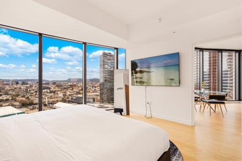 een slaapkamer met een wit bed en grote ramen bij 3 Bed 3 Bath Penthouse at Prime Location in Los Angeles