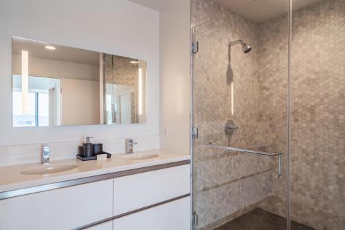 a bathroom with two sinks and a shower at 3 Bed 3 Bath Penthouse at Prime Location in Los Angeles