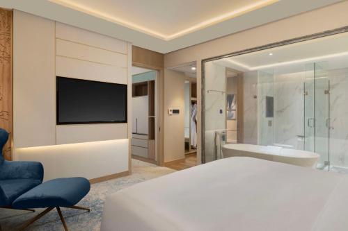 1 dormitorio con 1 cama, TV y bañera en Doubletree By Hilton Jakarta Bintaro Jaya en Serpong