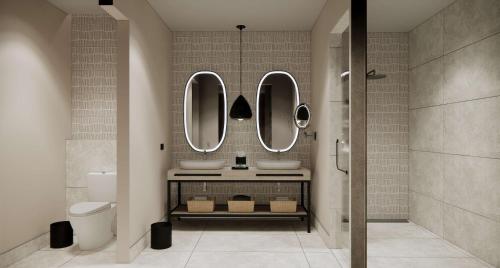 uma casa de banho com dois lavatórios e dois espelhos em Zemi Miches All-Inclusive Resort, Curio Collection By Hilton em Miches