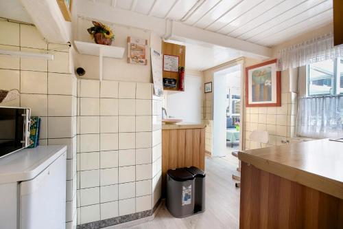 a kitchen with white tile walls and a counter at Ferienhaus Bruhn in Flensburg