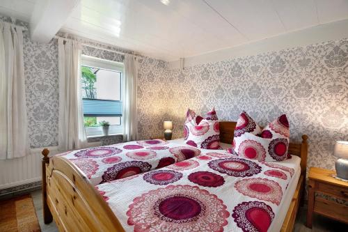 a bedroom with a large bed with red and white pillows at Ferienhaus Bruhn in Flensburg