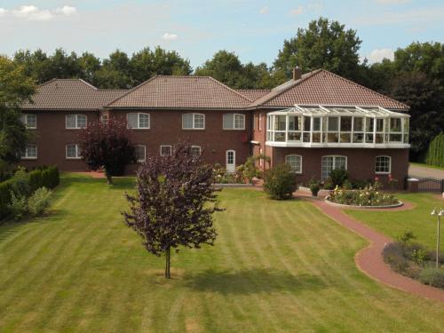 a large brick house with a large yard at Hotel-Garni Herzog in Loher Ostmark