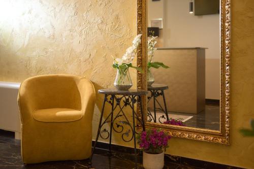 a mirror and a chair and a table with flowers at Villa Žnjan in Split