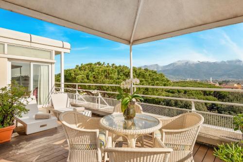 a patio with a table and chairs on a balcony at Hotel Excelsior in Marina di Massa