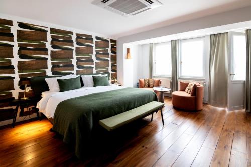 ein Schlafzimmer mit einem großen Bett und einer grünen Decke in der Unterkunft Hotel 'T Sandt in Antwerpen