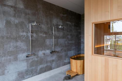 a bathroom with two shower stalls on a wall at SAKIA stay in Awaji