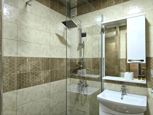 a bathroom with a sink and a glass shower at Mayberry Highway - Apartmani Medijapark in Sveti Nikole