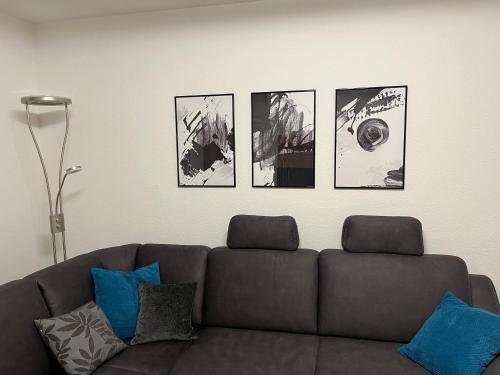 un soggiorno con divano e 4 immagini sul muro di Ferienwohnung TAUNUSIDYLLE 