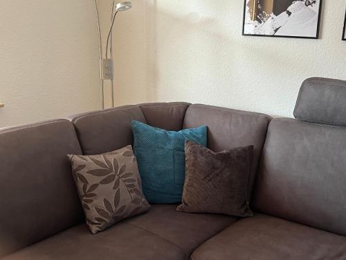 a brown couch with pillows on it in a living room at Ferienwohnung TAUNUSIDYLLE 
