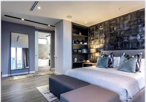 a bedroom with a large bed with blue pillows at The RoyalPlatinum Penthouse in Johannesburg