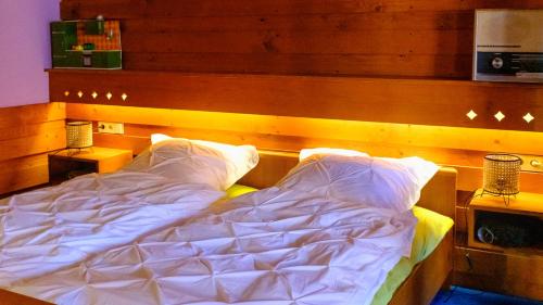 an unmade bed in a bedroom with a wooden headboard at BirnenhofArts in Bad Rodach