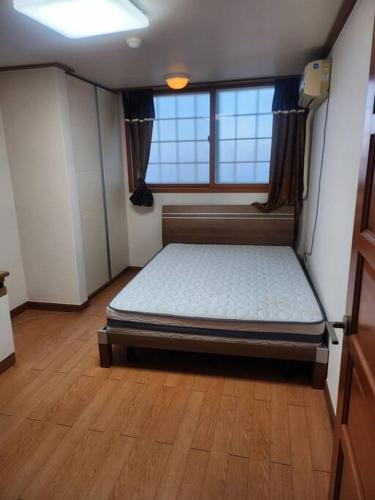 a bedroom with a bed in the middle of a room at house for rest in Geoje