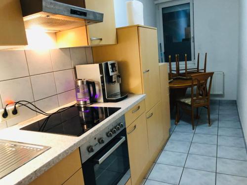 a kitchen with a stove top oven next to a table at quiet apartment in middle of city centre in Tuttlingen