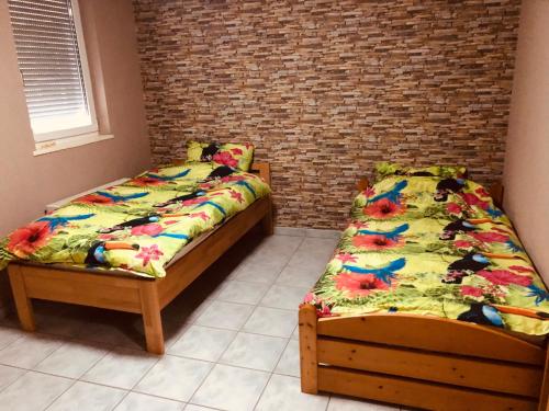 two twin beds in a room with a brick wall at quiet apartment in middle of city centre in Tuttlingen