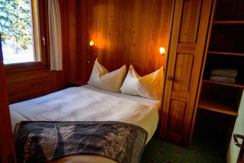 Schlafzimmer mit einem Bett mit weißer Bettwäsche und Kissen in der Unterkunft Seeblick in Arosa