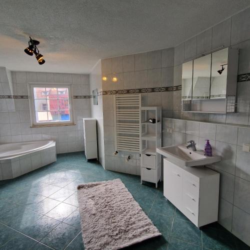 y baño con bañera, lavamanos y bañera. en DM Hotes & Apartments - Apartment Dosborn 2A, en Dingelstädt