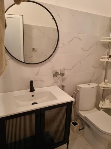 a bathroom with a sink and a mirror and a toilet at villa avec piscine in Somone