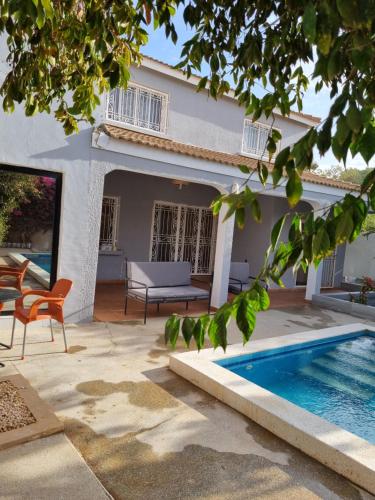 a villa with a swimming pool and a house at La villa Lisbonne in Somone