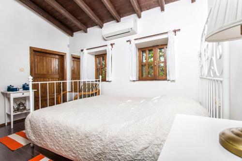 a white bedroom with a bed in a room at Original stone house with patio in the city center in Alacati