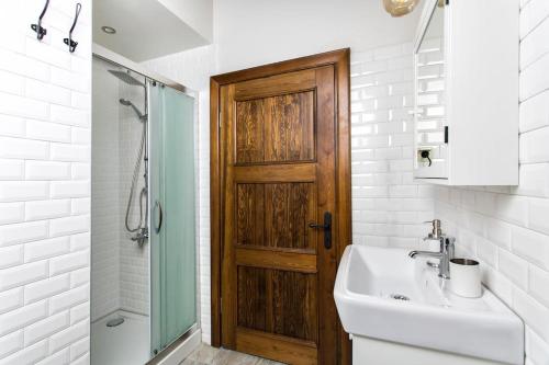 La salle de bains est pourvue d'un lavabo et d'une porte en bois. dans l'établissement Original stone house with patio in the city center, à Alaçatı