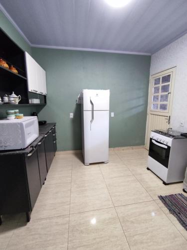 a kitchen with a white refrigerator in a room at Refúgio do Tucano in Alto Paraíso de Goiás